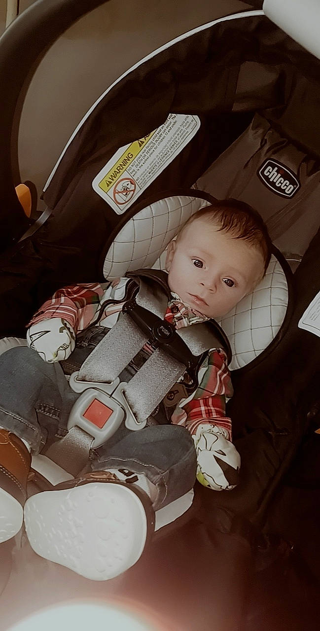 Hudson is registered to the contest to win money with this photo: auto_part, baby, baby_carriage, baby_products, baby_toys, bag, car_seat, car_seat_cover, carmine, child, comfort, costume, doll, fashion_accessory, fictional_character, motor_vehicle, person, personal_protective_equipment, sitting, stuffed_toy