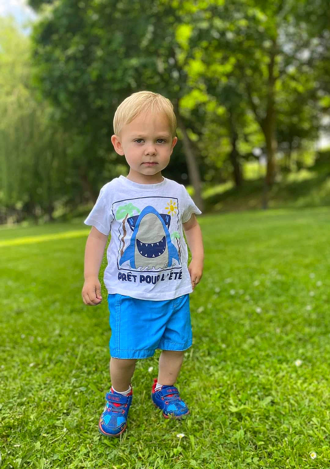 Eden a rejoint le concours — aidez-le/la à gagner de superbes lots ! baby_toddler_clothing, eye, facial_expression, grass, grassland, green, hair, happy, leaf, leisure, mammal, meadow, people_in_nature, person, plant, street_fashion, summer, t_shirt, toddler, tree