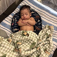 Mathias joined the competition — help win amazing prizes! baby, infant, sleeping, child, face, curly_hair, closed_eyes, peaceful, blanket, playpen, cushion, portrait, indoors, cozy, bedding, patterned_blanket, resting, arms_crossed, nap, photograph