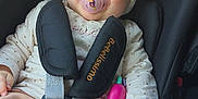Anna participe au concours pour gagner de l'argent avec cette photo : baby, beige, blue_eyes, car_seat, child, clothing, cute, fabric, hand, head_wrap, indoor, infant, pacifier, pink, portrait, safety, seatbelt, sitting, smiling, toy