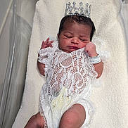 Zoey is registered to the contest to win money with this photo: newborn, baby, infant, sleeping, hospital, bassinet, crown, lace, dress, blanket, portrait, face, hair, feet, wristband, royalty, indoors, medical, resting, photography
