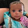 baby, infant, child, portrait, face, eyes, wide_eyed, curious, indoor, blanket, wrapped, pink_clothing, turquoise_blanket, adult, cuddling, closeup, sitting, soft_lighting, home, photography