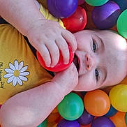 Milaya a rejoint le concours — aidez-le/la à gagner de superbes lots ! baby, child, colorful_balls, ball_pit, yellow_shirt, daisy, happy, smiling, playtime, hand, face, blue_eyes, cute, infant, indoors, plastic_balls, bright_colors, fun, toy, closeup