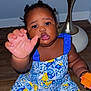 Salimatou Bah is registered to the contest to win money with this photo: toddler, child, dress, patterned_clothing, blue, yellow, toy, orange, floor, wooden_floor, lamp, indoor, curly_hair, reaching_hand, playful, person, sitting, home, expression, bright_colors