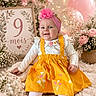 Ariel participe au concours pour gagner de l'argent avec cette photo : baby, balloons, celebration, child, cozy, cute, decor, fairy_lights, flower, flowers, happy, indoor, milestone, pink_headband, portrait, sign, sitting, smiling, soft, yellow_dress