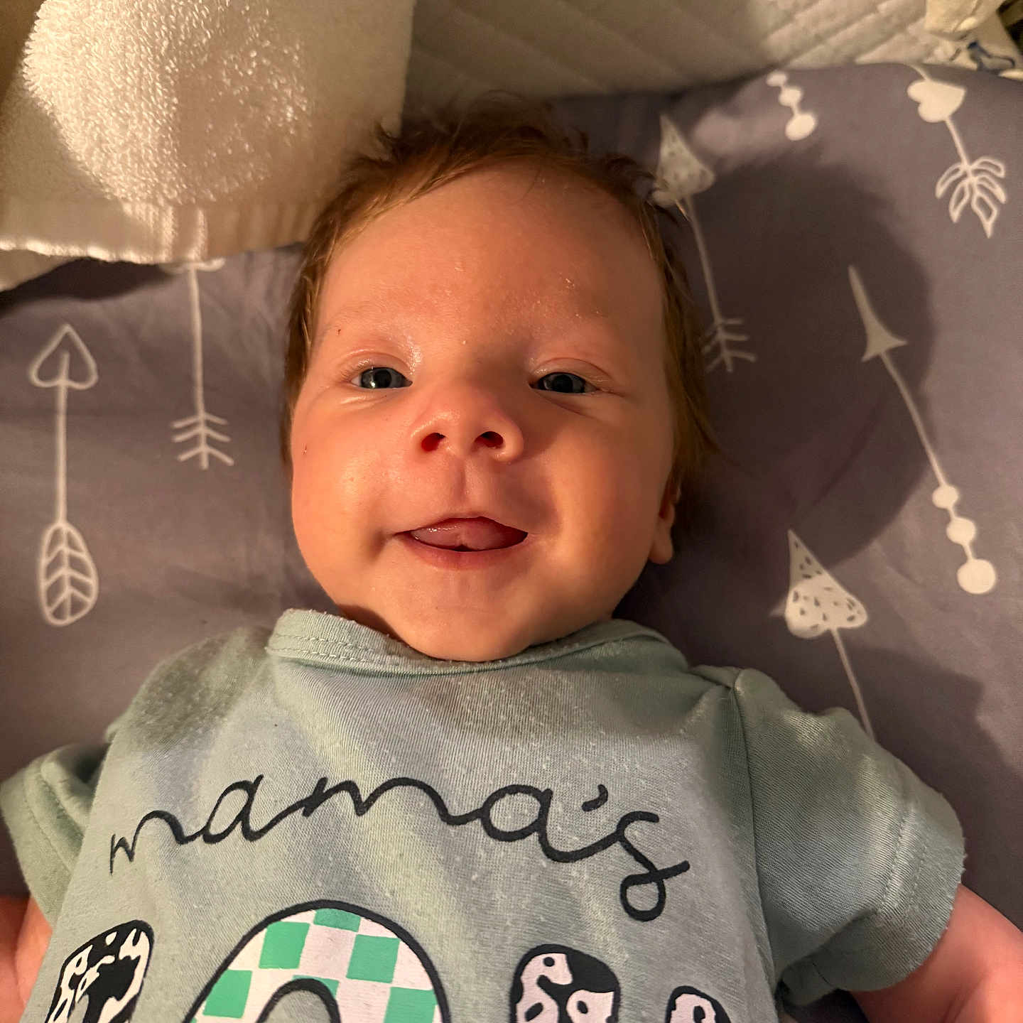 Liam joined the competition — help win amazing prizes! apparel, baby, blanket, child, closeup, clothing, cute, fabric, face, happy, indoor, infant, lying_down, pattern, person, smiling, soft_lighting, toddler, tongue_out, young_child