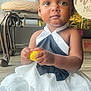 black_bow, celebration, chair, child, cute, dress, floor, hair_bows, indoors, party, person, pink_bows, portrait, sitting, socks, toddler, toy, white_dress, yellow_toy, young_child