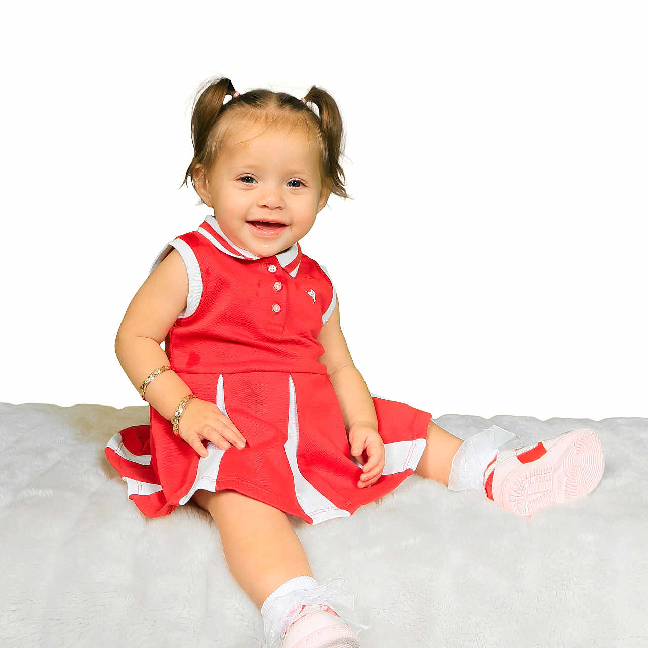 Vanecia is registered to the contest to win money with this photo: child, toddler, girl, smiling, portrait, red_dress, pink_shoes, pigtails, sitting, blanket, white_background, indoors, baby, happy, face, clothing, footwear, studio_photo, bracelet, playful