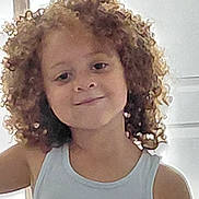 De'Winter is registered to the contest to win money with this photo: child, curly_hair, smile, tank_top, portrait, indoor, person, face, young, casual_clothing, light, background, happy, cute, head_and_shoulders, skin, expression, childhood, photography, people