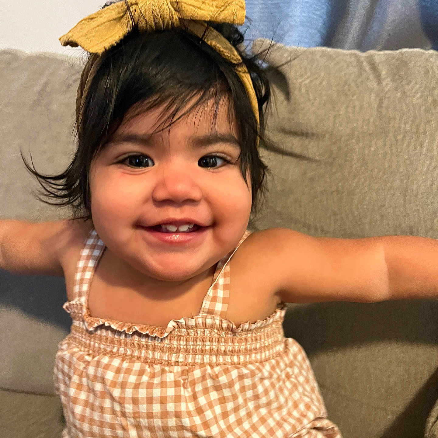 Natalia is registered to the contest to win money with this photo: accessories, baby, babylaughing, bodypart, clothing, couch, cushion, dress, face, furniture, happy, head, headband, homedecor, laughing, mouth, person, photography, portrait, smile