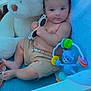 baby, child, sunglasses, stuffed_toy, teddy_bear, toy, blue, shirtless, shorts, indoor, chair, infant, cute, relaxed, playful, person, smiling, hand, foot, face