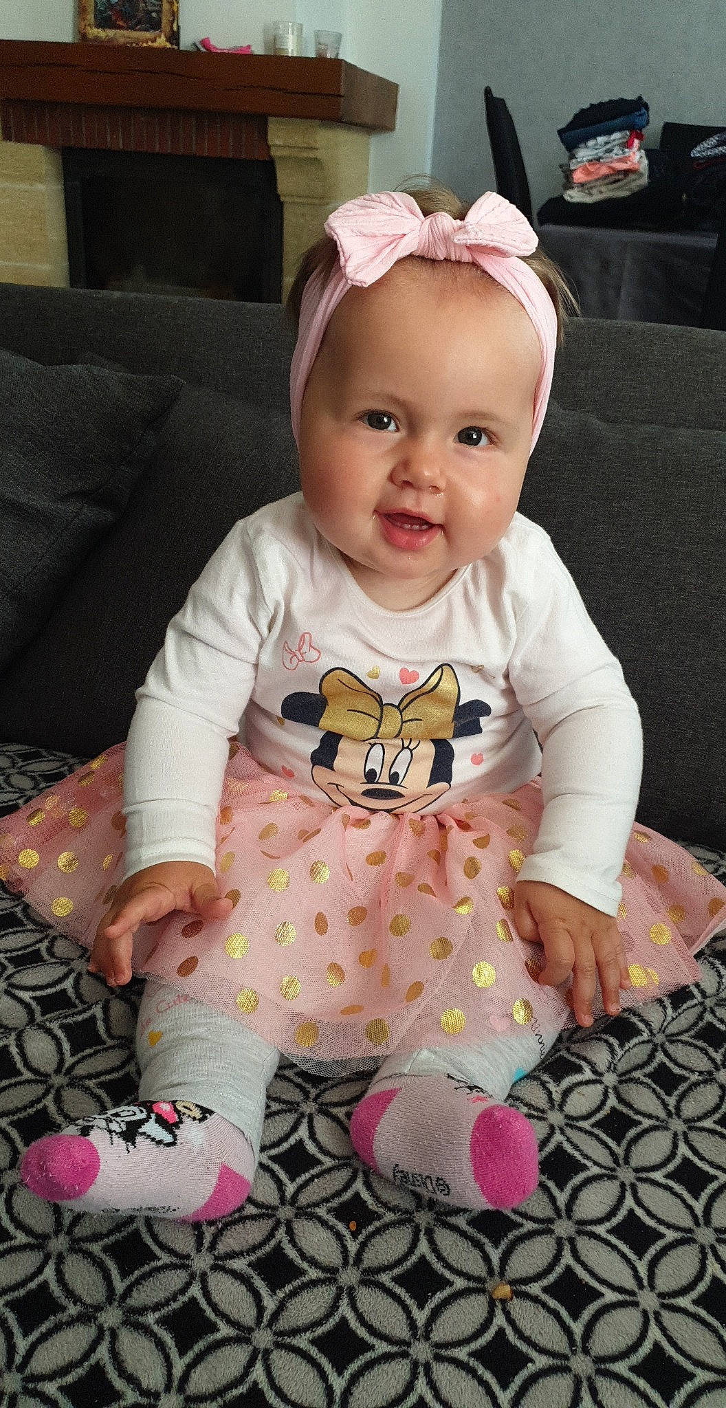 Kélia a rejoint le concours — aidez-le/la à gagner de superbes lots ! baby, baby_toddler_clothing, cap, cheek, child, comfort, couch, facial_expression, happy, linens, magenta, pattern, person, pink, sitting, skin, sleeve, smile, t_shirt, toddler