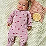 baby, infant, smiling, onesie, pink, apple_pattern, blanket, soft_texture, bunny_comforter, wooden_marker, milestone, lying_down, cute, child, face, happy, indoors, portrait, cozy, sleepwear