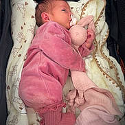 Lilou participe au concours pour gagner de l'argent avec cette photo : baby, infant, pacifier, pink_clothing, stuffed_toy, bunny_toy, blanket, stroller, sleeping, cozy, cute, soft_toy, child, newborn, comfort, warm, indoors, resting, teddy_bear_pattern, sock
