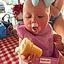 Addison is registered to the contest to win money with this photo: baby, ice_cream, cone, blue_bow, bib, purple_bib, tablecloth, checkered, red_and_white, frozen_treat, hand, person, outdoor, summer, food, messy, cute, child, sitting, mouth
