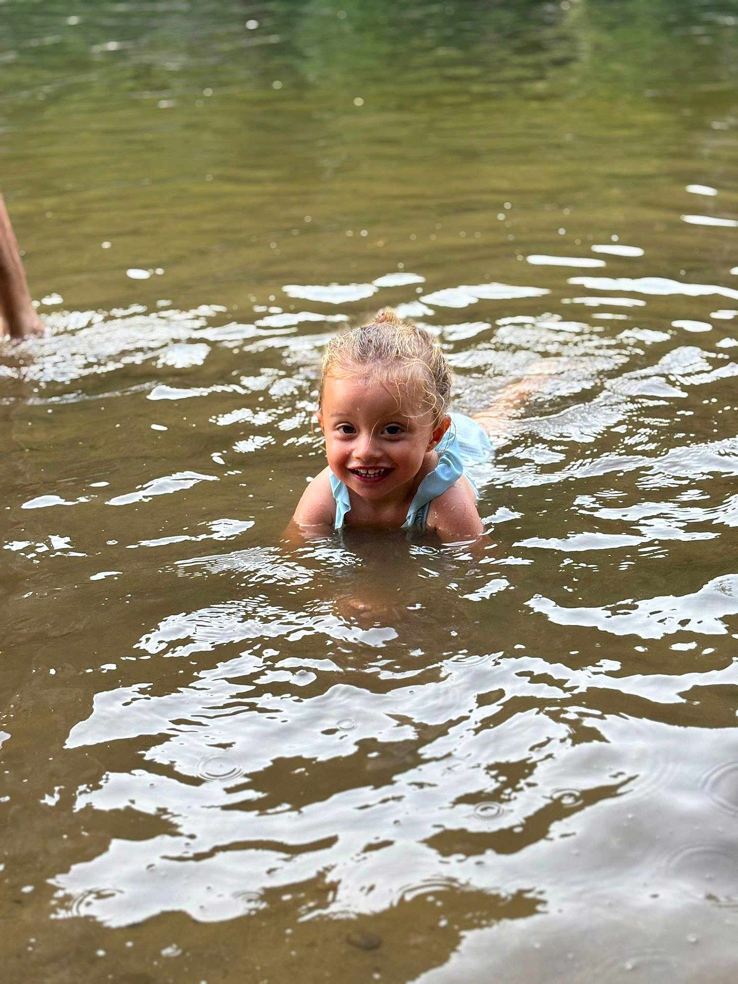 Capucine participe au concours pour gagner de l'argent avec cette photo : child, water, smiling, playing, outdoor, river, wet_hair, happy, summer, nature, reflection, face, person, recreation, fun, splash, young, light, ripples, casual
