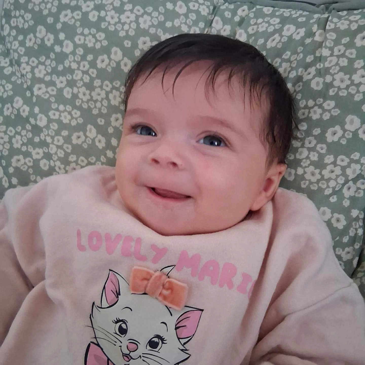 Aluney participe au concours pour gagner de l'argent avec cette photo : baby, bow, cartoon, cat, child, clothing, cushion, cute, face, floral, hair, happy, indoors, infant, pattern, pink, portrait, skin, smiling, sweatshirt
