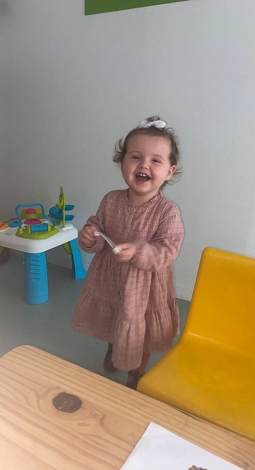 Innaya participe au concours pour gagner de l'argent avec cette photo : baby_toddler_clothing, child, comfort, floor, flooring, fun, happy, hardwood, joy, person, play, room, sitting, sleeve, smile, sock, standing, table, toddler, wood