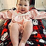 baby, infant, child, pink_clothing, plaid, legs, blanket, mickey_mouse, red, black, indoor, carpet, door, wall_outlet, smiling, face, feet, toes, person, home