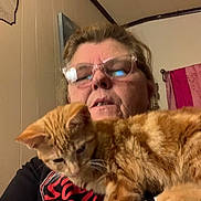Butter is registered to the contest to win money with this photo: woman, glasses, cat, orange_tabby, indoor, selfie, shirt, towel, wall, curious, pet, feline, face, person, home, casual, closeup, portrait, animal, resting