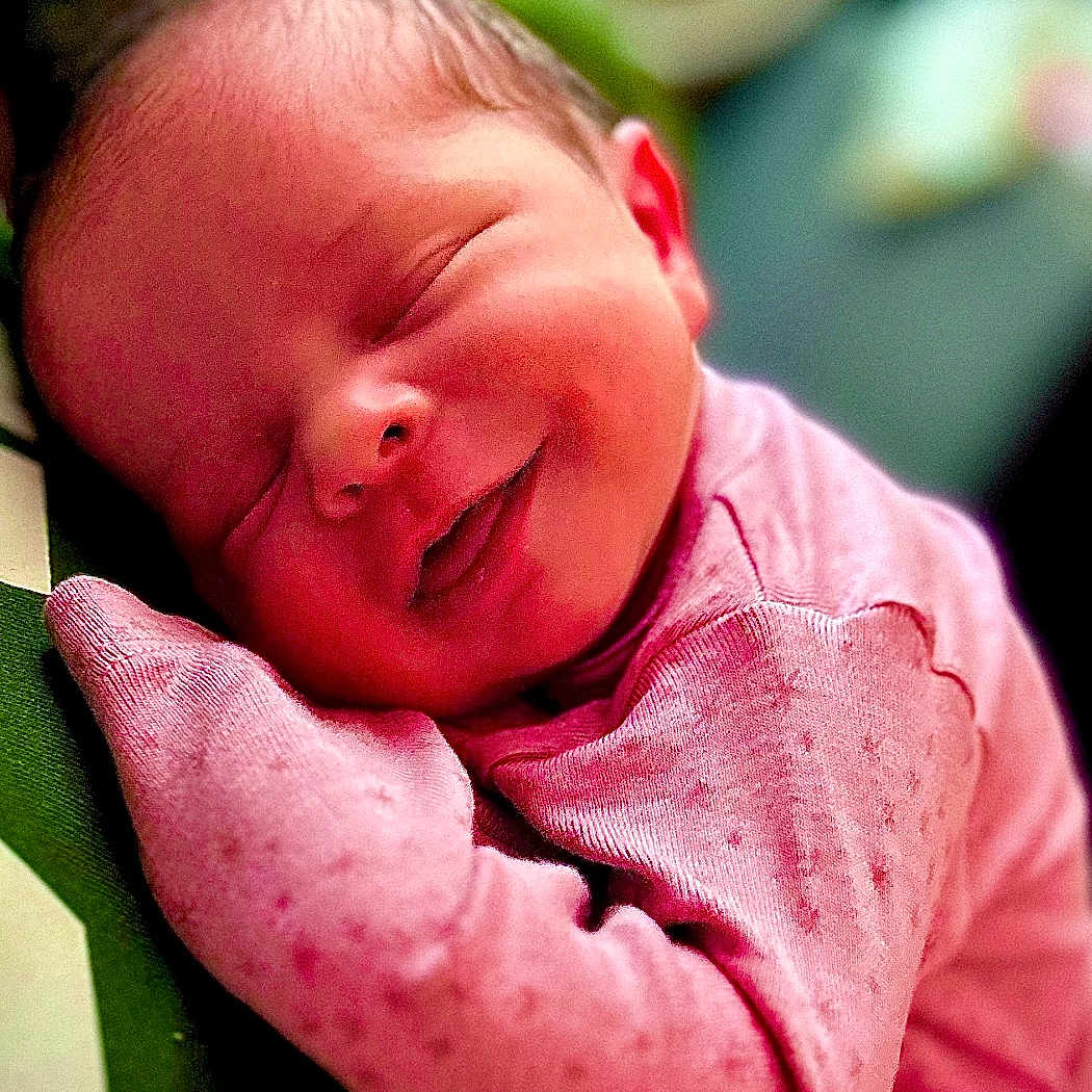 Harper is registered to the contest to win money with this photo: baby, blanket, bodypart, clothing, cushion, face, finger, glove, hand, happy, head, homedecor, newborn, person, photography, portrait, sleeping, smile