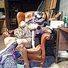 armchair, can, casual, chair, clutter, dog, furniture, garage, hand, happy, indoor, legs, patterned_leggings, person, pet, seated, sneakers, table, tattoo, workshop