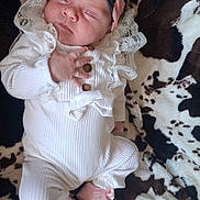 Lou a rejoint le concours — aidez-le/la à gagner de superbes lots ! baby, infant, sleeping, headband, flower, pink, white_clothing, ruffles, buttons, blanket, soft_texture, footwear, shoes, bow, patterned_background, cute, newborn, lying_down, child, portrait