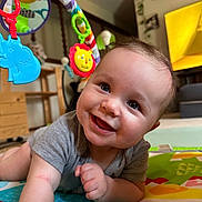 Atlas is registered to the contest to win money with this photo: baby, background, bright, cheerful, child, clothing, colorful, crawling, cute, development, face, furniture, happy, home, indoor, infant, person, play_mat, smiling, toy