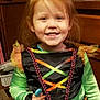 Hope joined the competition — help win amazing prizes! child, smiling, costume, indoor, red_hair, dress, toy, furniture, cabinet, happy, person, face, home, holding, colorful_clothing, curly_hair, playful, young, portrait, bright