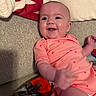 Blakely joined the competition — help win amazing prizes! baby, infant, smile, happy, onesie, pink_clothing, heart_pattern, couch, blanket, pillow, indoor, person, child, cute, portrait, skin, head, hand, laying_down, cozy