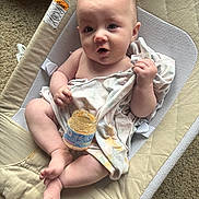Blakely is registered to the contest to win money with this photo: baby, infant, baby_food, blanket, baby_seat, carpet, face, hands, legs, feet, skin, clothing, jar, food, indoor, cute, expression, sitting, child, curious