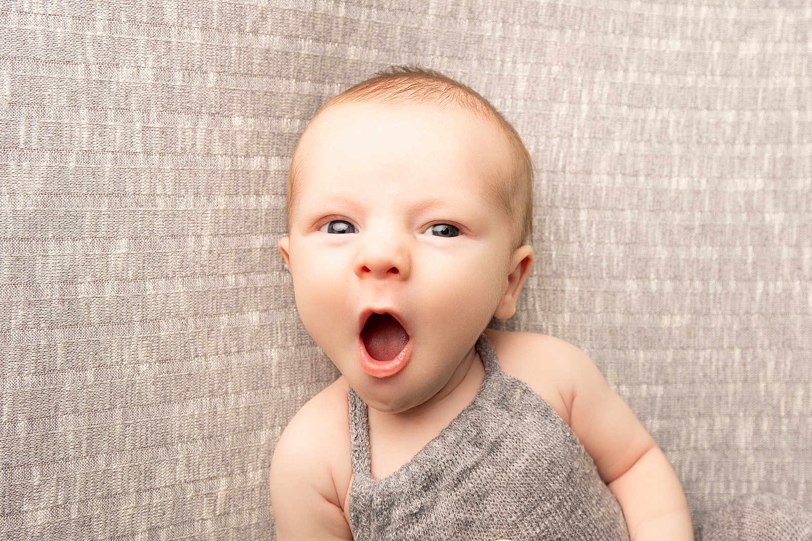 Stirling joined the competition — help win amazing prizes! baby, infant, yawning, knitted_clothing, neutral_background, cute, portrait, face, skin, head, child, expression, eyes, mouth, arm, soft_texture, indoors, newborn, person, photography