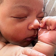 Elijah is registered to the contest to win money with this photo: baby, infant, sleeping, close_up, face, hand, fist, cheeks, skin, newborn, peaceful, soft, blanket, resting, portrait, child, cute, natural_light, indoors, calm