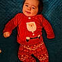 baby, child, smiling, red_clothing, santa_claus, pajamas, festive, holiday, blue_blanket, texture, lying_down, cute, indoors, portrait, infant, happy, cozy, warm_clothing, face, person