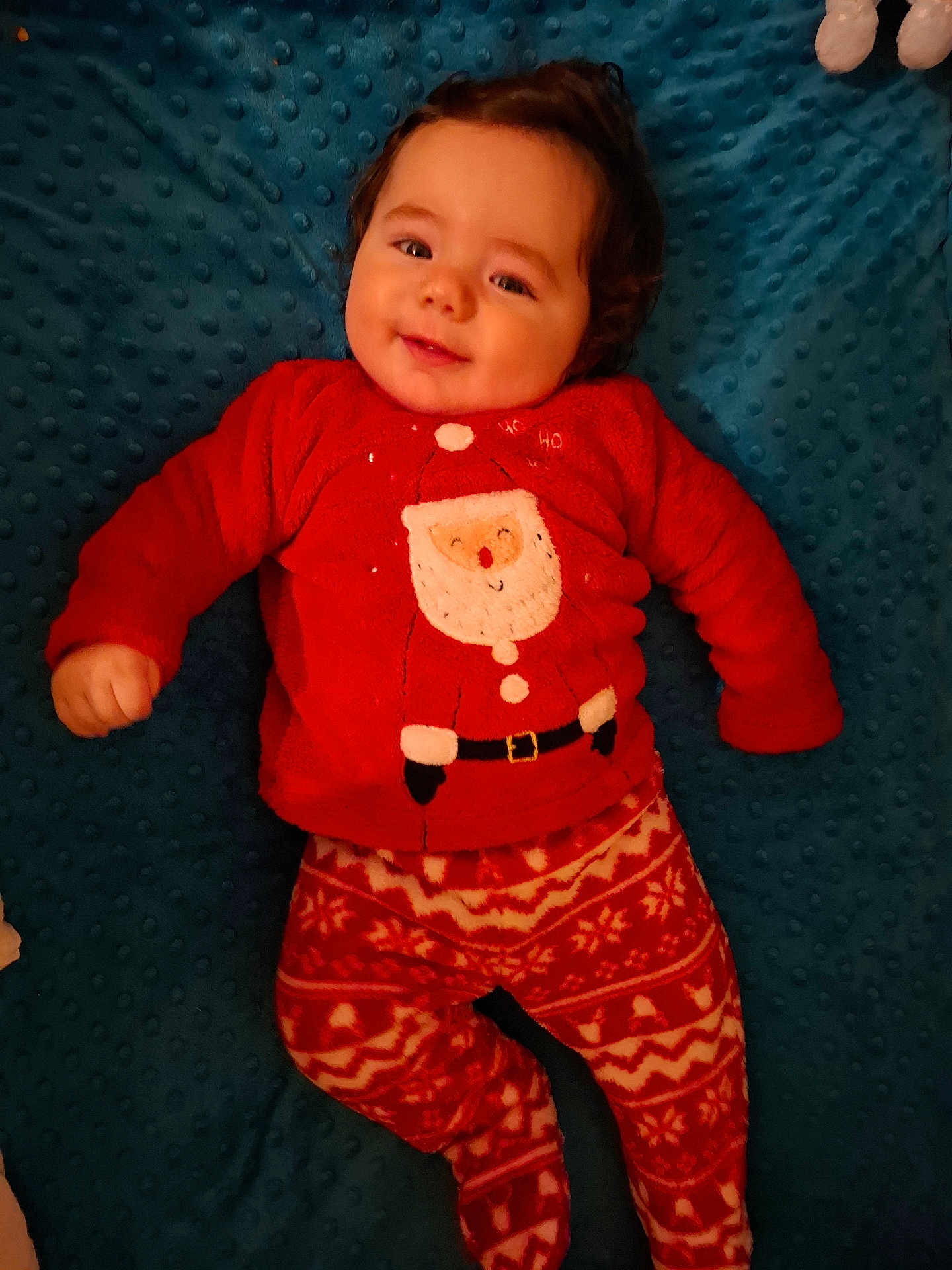 Maé a rejoint le concours — aidez-le/la à gagner de superbes lots ! baby, child, smiling, red_clothing, santa_claus, pajamas, festive, holiday, blue_blanket, texture, lying_down, cute, indoors, portrait, infant, happy, cozy, warm_clothing, face, person