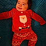 Maé participe au concours pour gagner de l'argent avec cette photo : baby, child, smiling, red_clothing, christmas_pajamas, santa_design, blanket, blue_blanket, cute, indoors, infant, happy, portrait, lying_down, holiday, festive, warm_clothing, toddler, cozy, soft_texture
