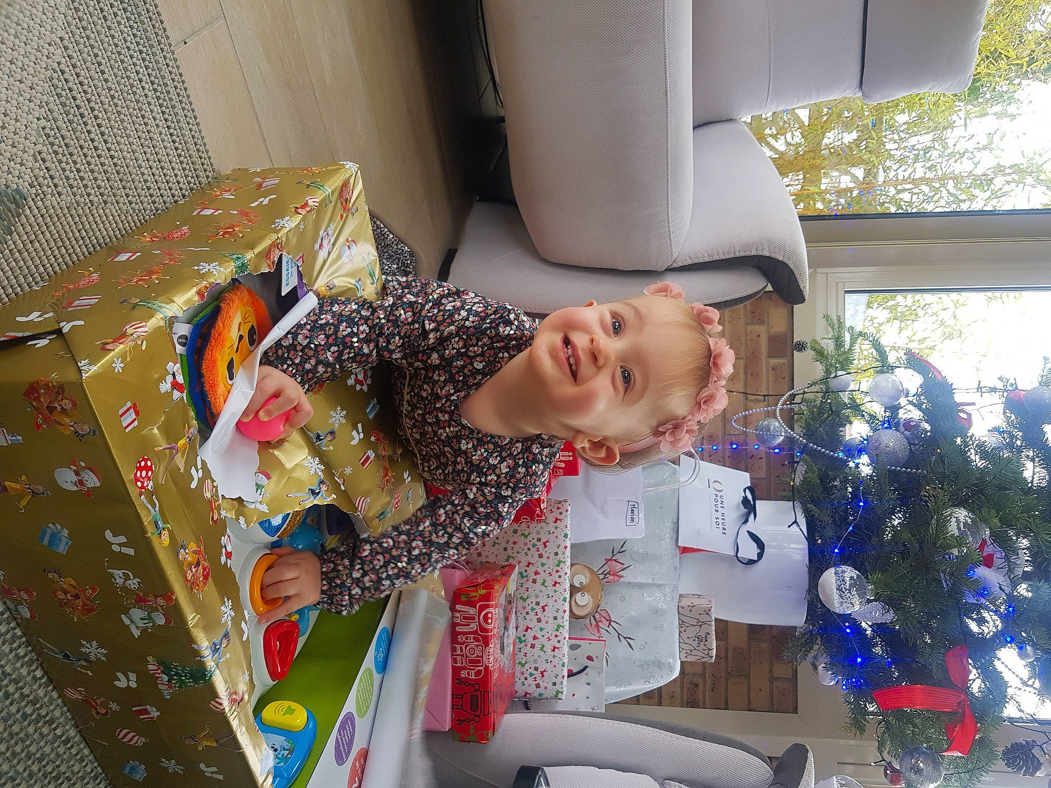 Julie participe au concours pour gagner de l'argent avec cette photo : child, christmas_tree, event, fir, fun, happy, holiday, joy, leisure, ornament, paper_product, pattern, person, play, room, smile, space, toddler, tree, visual_arts