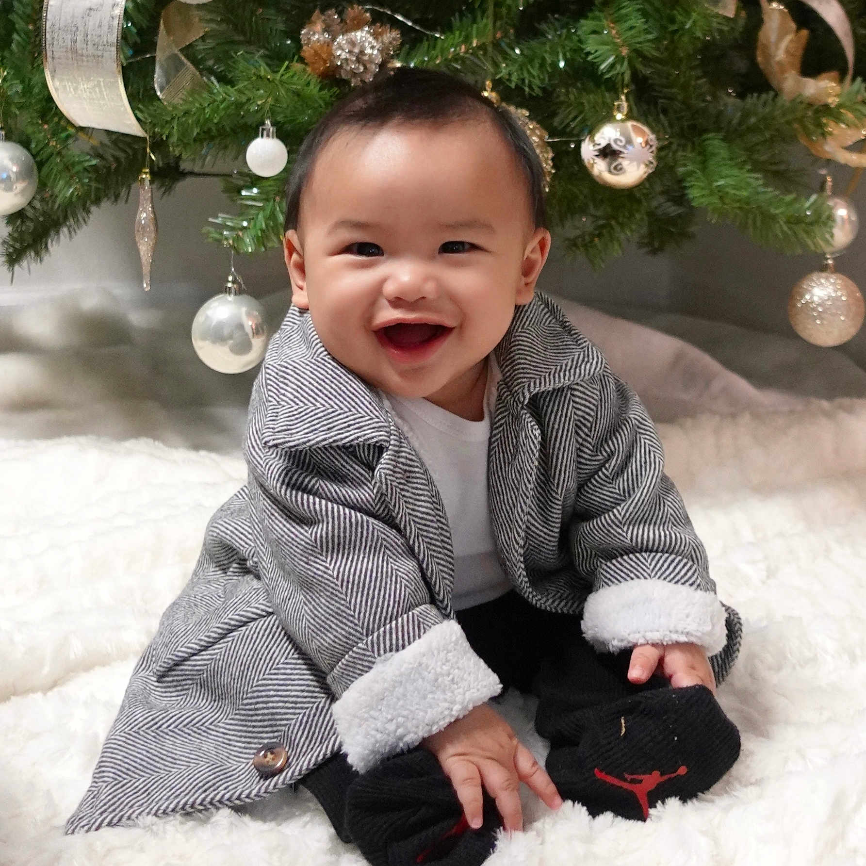 Roland Kyle joined the competition — help win amazing prizes! baby, blanket, celebration, child, christmas_tree, coat, cute, decor, festive, happy, holiday, indoor, infant, ornaments, person, ribbons, seasonal, smiling, socks, winter_clothing