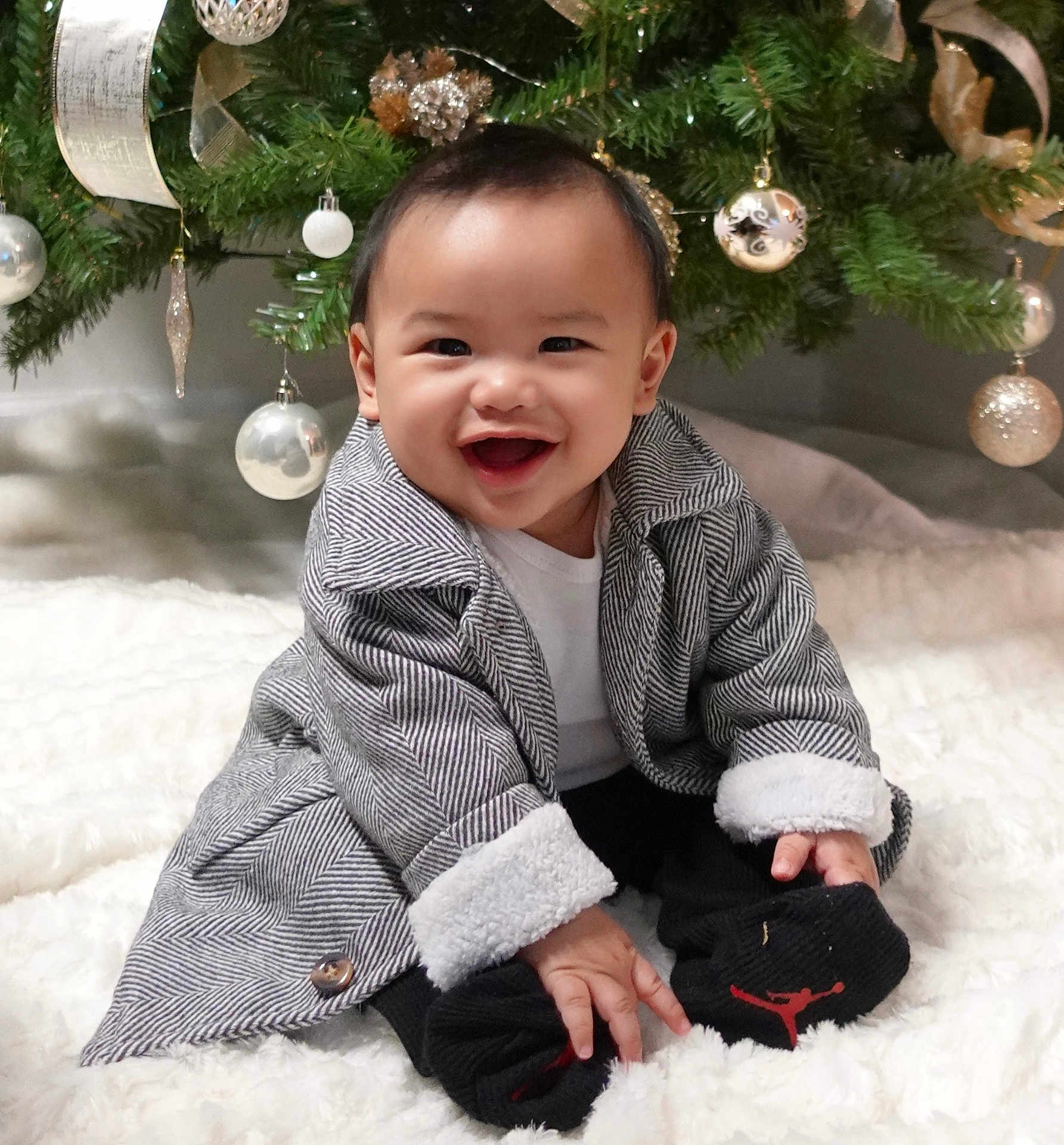 Roland Kyle joined the competition — help win amazing prizes! baby, child, smiling, coat, socks, christmas_tree, ornaments, ribbons, blanket, holiday, indoor, cute, festive, happy, celebration, person, infant, winter_clothing, decor, seasonal