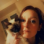 Tacha participe au concours pour gagner de l'argent avec cette photo : woman, cat, siamese_cat, selfie, indoor, portrait, face, pet, animal, furry, holding, closeup, warm_lighting, filter, star_effects, hair, eyes, calm, cute, cozy