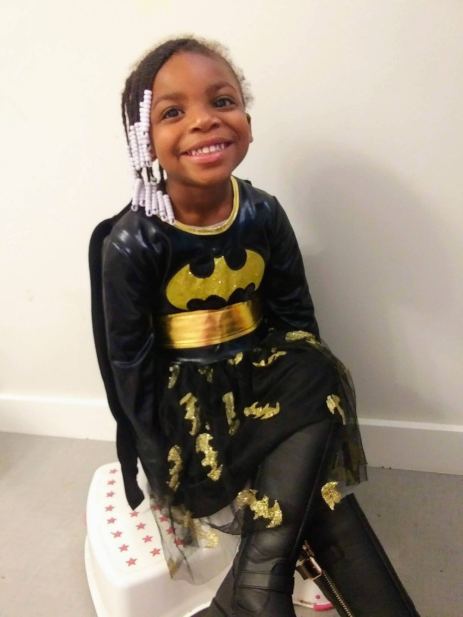 Jaida is registered to the contest to win money with this photo: art, baby_toddler_clothing, carmine, child, costume, doll, fashion_accessory, fashion_design, happy, head, joy, knee, outerwear, pattern, person, personal_protective_equipment, sitting, sleeve, smile, t_shirt