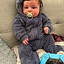Henry is registered to the contest to win money with this photo: baby, child, pacifier, fluffy_suit, hooded_jumpsuit, couch, blanket, controller, gaming_controller, playstation, blue_controller, indoor, soft_texture, cute, infant, seated, furniture, hand, face, young_child