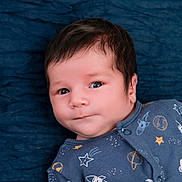 Henry joined the competition — help win amazing prizes! baby, infant, face, eyes, hair, blue_onesie, space_print, stars, rocket, planet, blanket, lying_down, portrait, cute, child, newborn, soft_light, indoors, closeup, expression