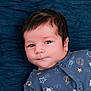 baby, blanket, blue_onesie, child, closeup, cute, expression, eyes, face, hair, indoors, infant, lying_down, newborn, planet, portrait, rocket, soft_light, space_print, stars