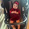 Iliany Diaz is registered to the contest to win money with this photo: baby, child, stroller, red_dress, headband, bow, footwear, indoor, light, curious, smile, person, infant, portrait, seated, clothing, cute, hands, face