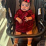 Iliany Diaz joined the competition — help win amazing prizes! baby, child, stroller, red_dress, headband, bow, white_sandals, indoors, floor_tiles, curious_expression, sitting, hand_gesture, footwear, person, infant, cute, plush, portrait, clothing, furniture