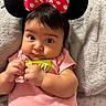 baby, infant, mickey_mouse_ears, headband, pink_shirt, cute, wide_eyes, polka_dot, bow, soft_blanket, hand_clutching, indoors, portrait, child, adorable, chubby_cheeks, expression, lying_down, baby_clothing, close_up
