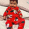 baby, infant, child, red_clothing, minnie_mouse, headband, bow, smile, cheeks, bed, pillow, patterned_bedding, cute, indoors, portrait, sitting, happy, person, soft_texture, comfortable