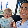 Alexandro joined the competition — help win amazing prizes! baby, child, woman, car_interior, smile, face, window, flag, light, clothing, short_sleeve, gold_chain, hair, skin, seated, holding, happy, daylight, casual, portrait