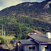 Peppa participe au concours pour gagner de l'argent avec cette photo : architecture, biome, building, city, cloud, highland, house, landscape, mountain, mountain_range, mountainous_landforms, natural_landscape, plant, residential_area, rural_area, sky, slope, tree, vegetation, window